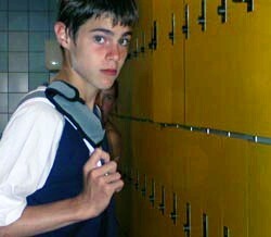 boy in swim shirt next to pool lockers